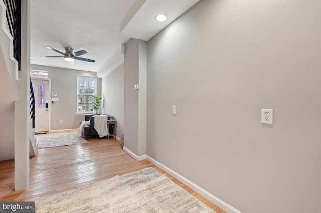 interior space with stairs, a ceiling fan, light wood-style flooring, and baseboards