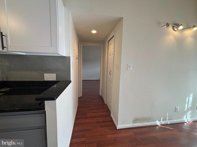 corridor with recessed lighting, dark wood-style flooring, and baseboards