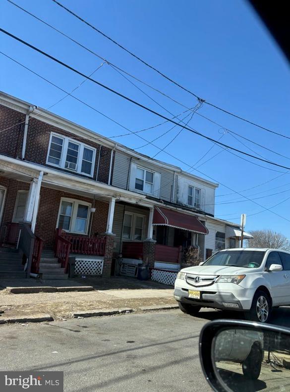 multi unit property with a porch and brick siding