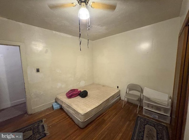 bedroom featuring wood finished floors, a ceiling fan, and baseboards