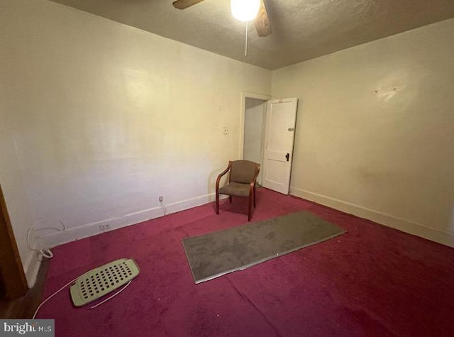 interior space featuring carpet floors, ceiling fan, a textured ceiling, and baseboards