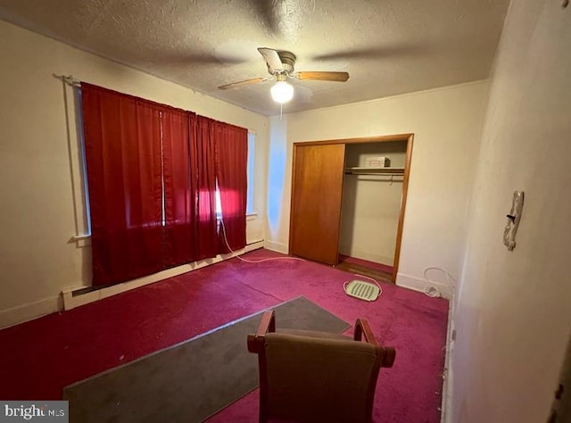 carpeted bedroom with a textured ceiling, a closet, a ceiling fan, and baseboards