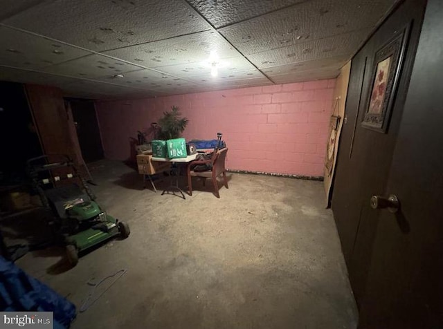 dining area featuring concrete flooring and concrete block wall