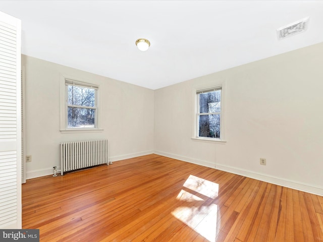 interior space featuring radiator, visible vents, baseboards, and light wood finished floors