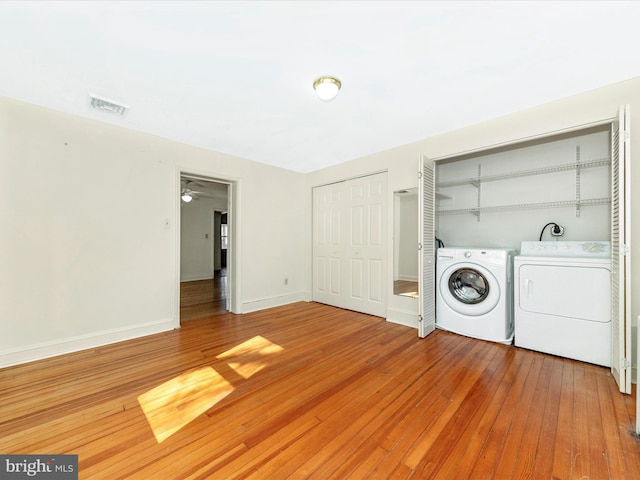 washroom featuring laundry area, baseboards, visible vents, hardwood / wood-style flooring, and washer and dryer