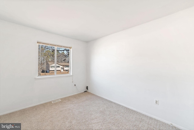 carpeted empty room with visible vents and baseboards