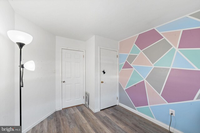 unfurnished bedroom featuring baseboards and wood finished floors