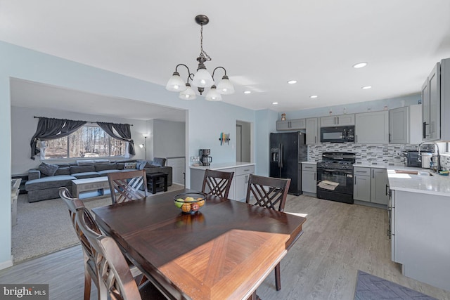 dining space with light wood-style floors, a notable chandelier, and recessed lighting