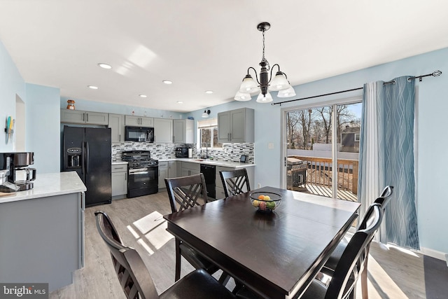 dining room featuring light wood finished floors, a wealth of natural light, and recessed lighting