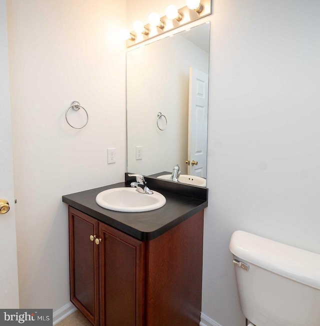 half bathroom featuring toilet and vanity