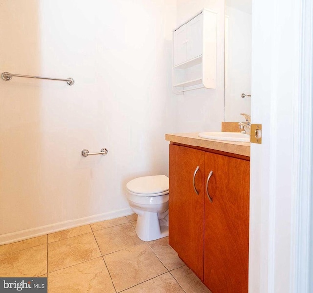 bathroom with baseboards, vanity, toilet, and tile patterned floors