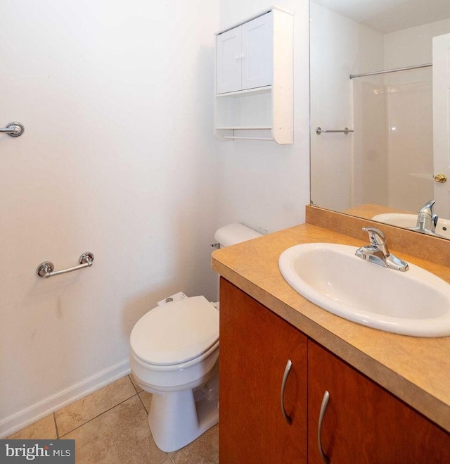 bathroom featuring baseboards, toilet, tile patterned flooring, walk in shower, and vanity