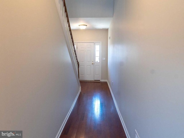 doorway to outside with dark wood-type flooring and baseboards