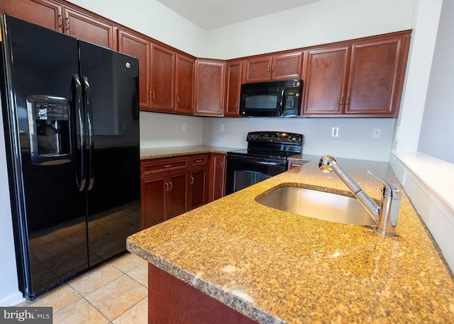 kitchen with light tile patterned floors, a peninsula, a sink, light countertops, and black appliances