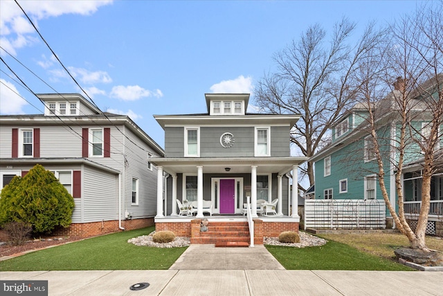 traditional style home featuring covered porch and a front lawn