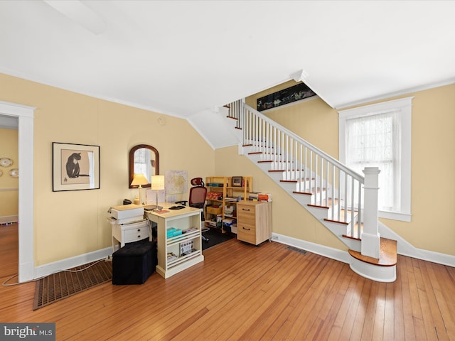 interior space with visible vents, baseboards, stairs, and hardwood / wood-style flooring