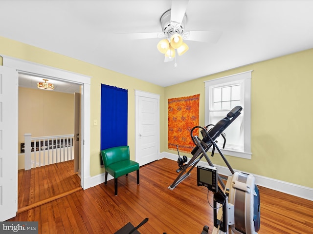 exercise area featuring baseboards, wood-type flooring, and a ceiling fan