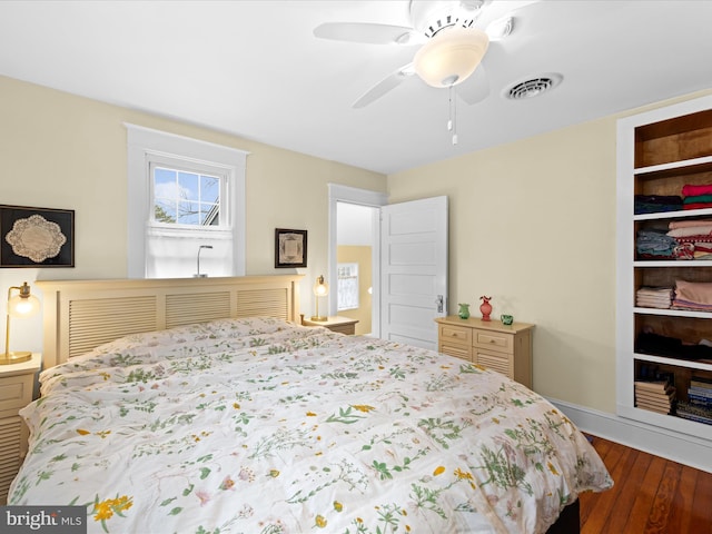 bedroom with wood finished floors, visible vents, and ceiling fan