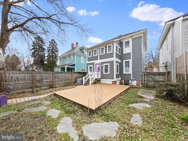 back of property featuring a fenced backyard, central AC, and a wooden deck