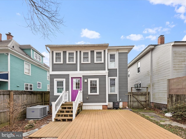 back of house featuring central AC unit and fence