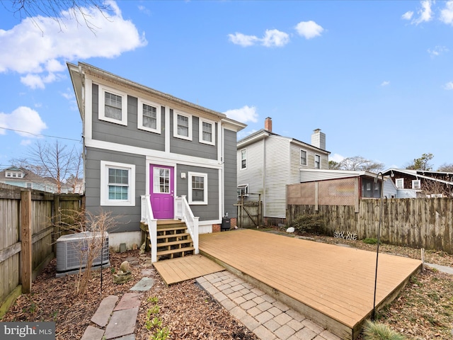 back of property with central AC unit, a fenced backyard, and a wooden deck