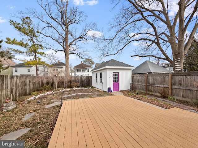 wooden terrace featuring an outdoor structure and a fenced backyard