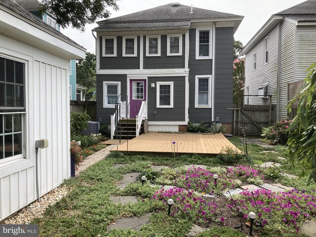 back of property with a gate, a wooden deck, central AC, and fence