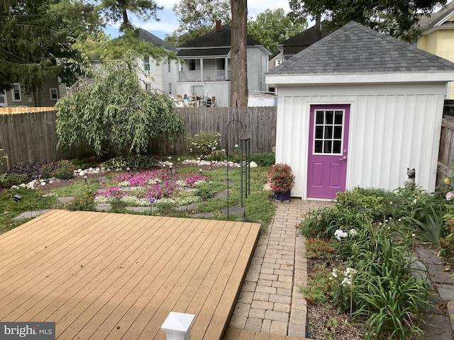 wooden deck featuring an outbuilding and fence