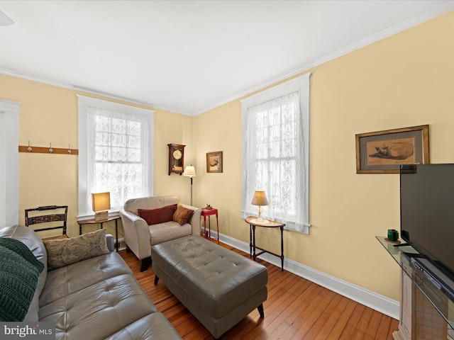 living room with ornamental molding, baseboards, and wood-type flooring