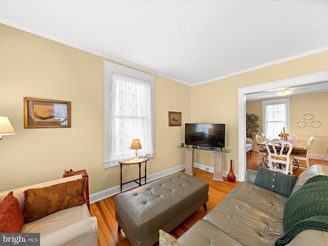 living room with baseboards, wood finished floors, and crown molding