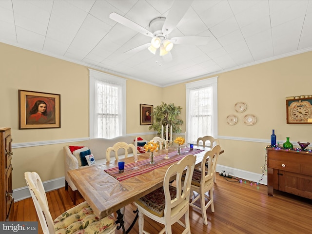 dining area with ceiling fan, wood finished floors, baseboards, and ornamental molding