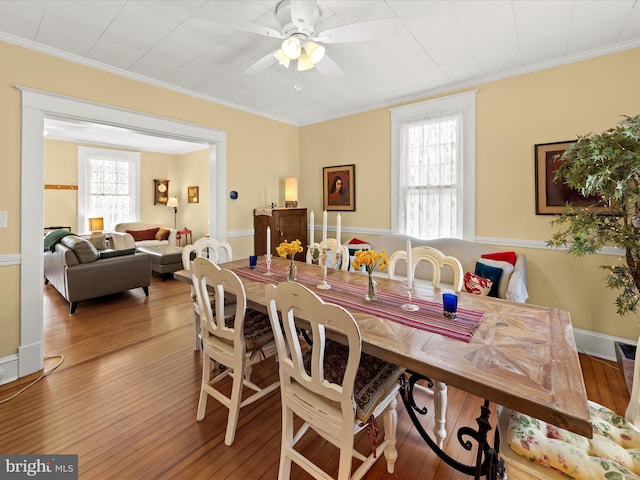 dining area with hardwood / wood-style flooring, crown molding, baseboards, and ceiling fan