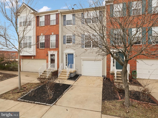 multi unit property featuring a garage, concrete driveway, and brick siding