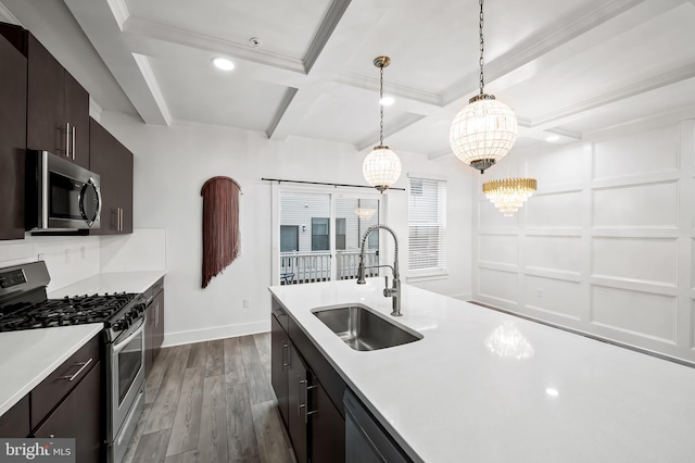 kitchen featuring dark wood-type flooring, a sink, stainless steel appliances, light countertops, and beam ceiling