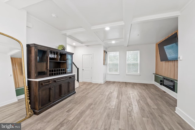 unfurnished living room with light wood-type flooring, baseboards, and beamed ceiling