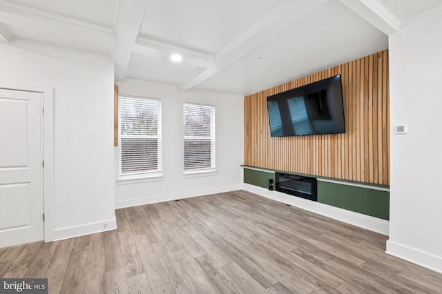 unfurnished living room featuring beamed ceiling, wood finished floors, and baseboards