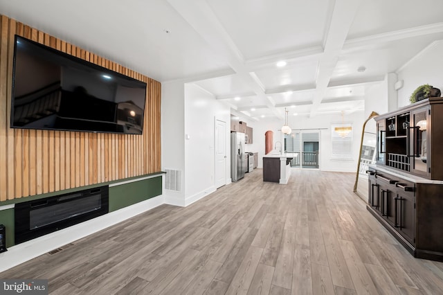 unfurnished living room with baseboards, visible vents, coffered ceiling, light wood-type flooring, and beam ceiling