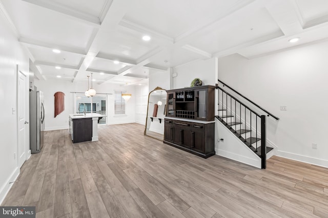 kitchen with arched walkways, light countertops, freestanding refrigerator, light wood-type flooring, and coffered ceiling