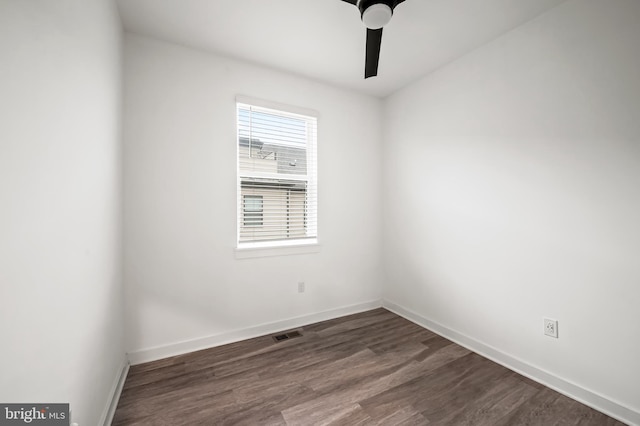 spare room featuring dark wood-style floors, visible vents, baseboards, and a ceiling fan