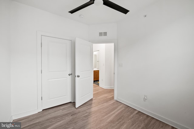 unfurnished bedroom with visible vents, ceiling fan, baseboards, and wood finished floors