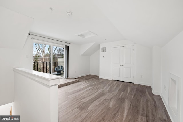 bonus room with attic access, baseboards, visible vents, wood finished floors, and vaulted ceiling