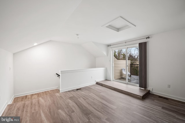 additional living space featuring visible vents, vaulted ceiling, baseboards, and wood finished floors