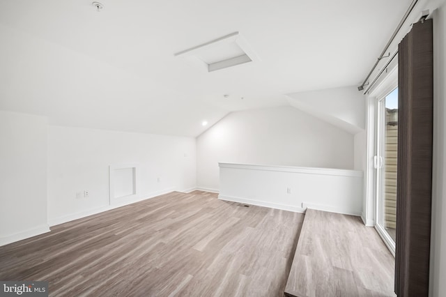 bonus room featuring attic access, lofted ceiling, baseboards, and wood finished floors