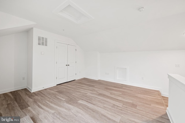 bonus room featuring attic access, baseboards, visible vents, lofted ceiling, and light wood-style flooring