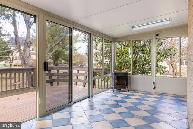 unfurnished sunroom featuring a wood stove