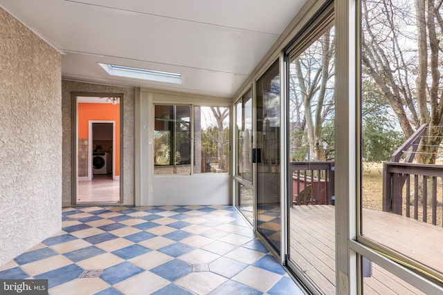 unfurnished sunroom featuring washer / clothes dryer and a skylight