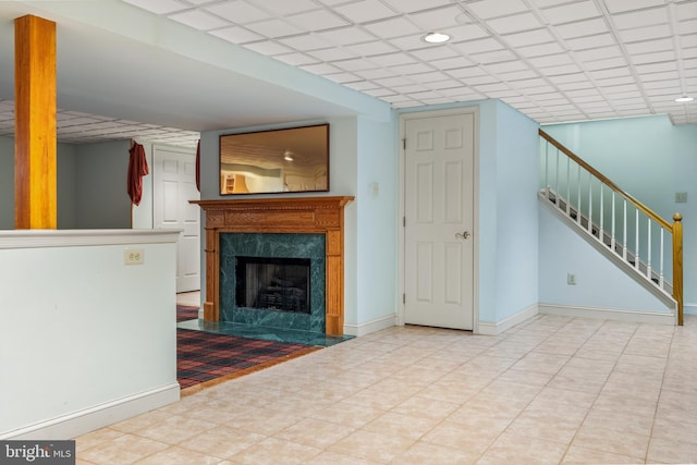 unfurnished living room featuring stairs, baseboards, and a premium fireplace