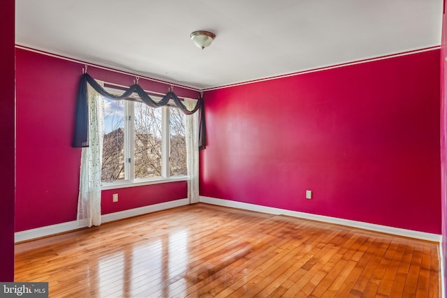 empty room with baseboards and hardwood / wood-style floors