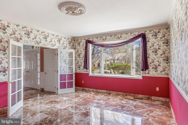 spare room with wallpapered walls, marble finish floor, crown molding, and french doors