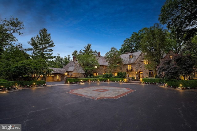 view of front facade with stone siding and aphalt driveway